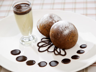 freshly baked brownie type sponge cake with vanilla sauce in a glass