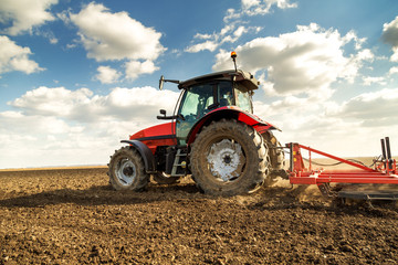 Farmer in tractor preparing land with seedbed cultivator