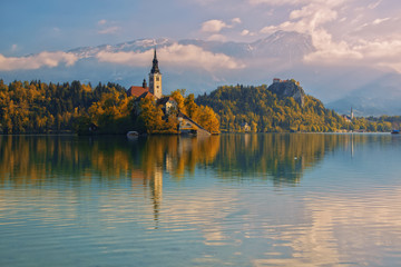 Bled lake and pilgrimage church with autumn mountain landscape background