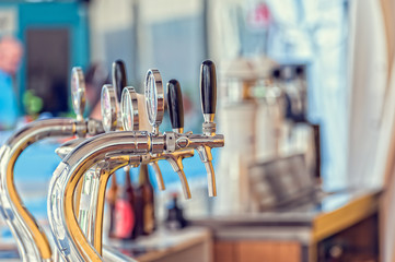 Draught beer taps in a bar. - obrazy, fototapety, plakaty