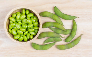 Green Japanese Soybeans in a wooden bowl on wooden background