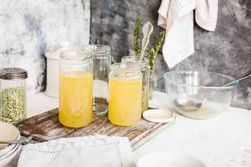 Bouillon glass jars over kitchen table. Preparation soup concept.