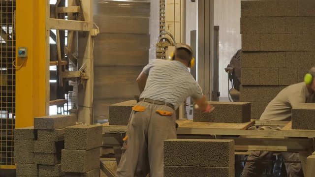 Foreman and worker doing his job at concrete blocks factory