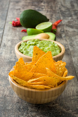 Nachos, guacamole and ingredients on wooden table

