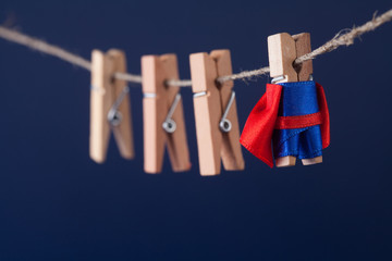 Powerful super hero conceptual photo with superstar clothespin character in blue suit red cape....