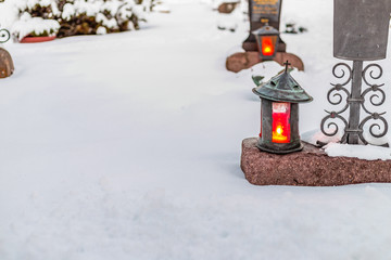 candles in a snowy cemetery