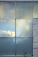 Wolkenreflektionen im Kunststofffenster / Wolken und der blaue Himmel spiegeln sich in geriffelten Kunststofffenstern.
