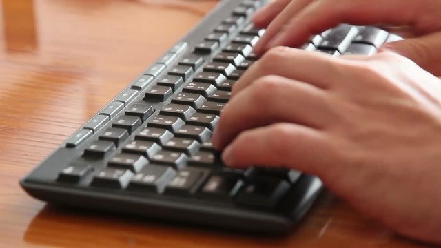 Closeup of male hands typing on keyboard
