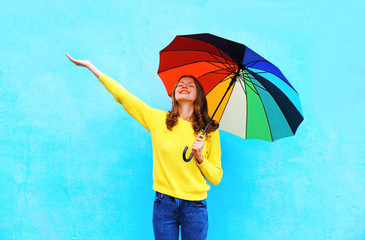 Happy smiling young woman holding colorful umbrella in autumn da