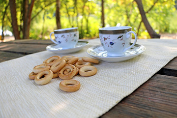 in nature, on the table bagels and cups, in a sunny warm day