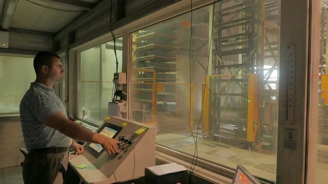Foreman controls the production from the operator's room on a concrete blocks factory