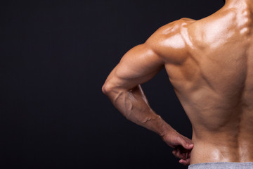 Rear view of a male bodybuilder flexing his back