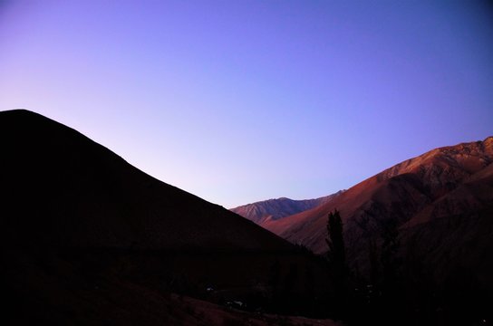 Sunset behind the black hills with a purple and blue sky in Pisco Elqui in Chile, South America