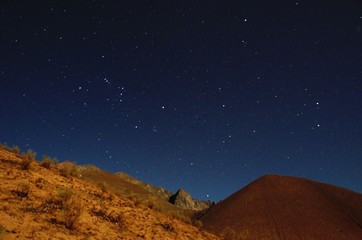 Fototapeta na wymiar Stargazing in Elqui Valley with hundreds of stars in the sky between black hills in Chile, South America