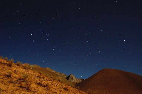 Stargazing in Elqui Valley with hundreds of stars in the sky between black hills in Chile, South America