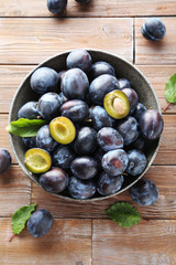 Tasty and ripe plums on brown wooden table