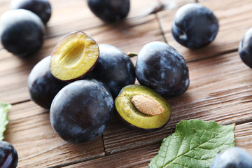 Tasty and ripe plums on brown wooden table