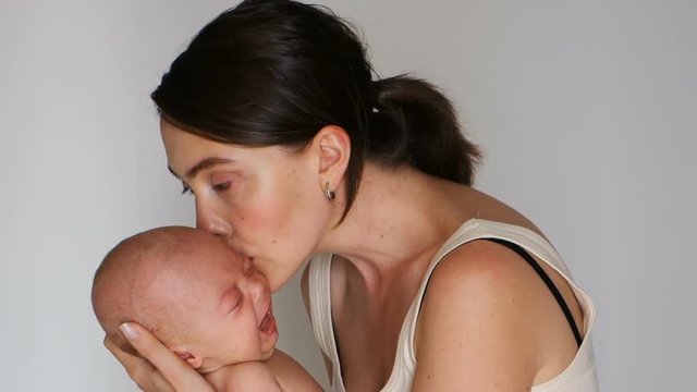 Woman holding a crying baby while hugs him