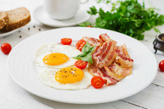English breakfast - fried egg, tomatoes and bacon.