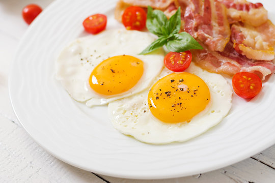 English breakfast - fried egg, tomatoes and bacon.