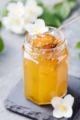 Jasmine flower confiture, jam with fresh jasmine flowers. Grey stone slate background