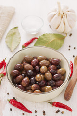 olives in bowl on white wooden background