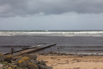 Lone man on the ocean. Autumn seascape in Doughmore, Ireland.