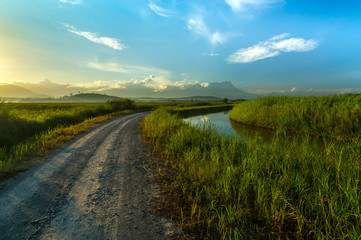 Curvy gravel road, irrigation and Mount Kinabalu scenery at Sangkir Kota Belud, Sabah