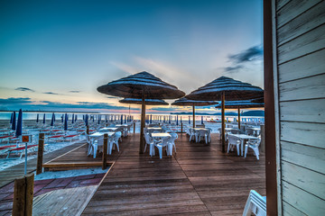 parasols on the beach at sunset