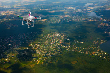 Quadrocopter flying over farmland at summer