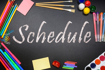 The title schedule on the chalkboard (school board) and school, office supplies (paints, pencils, brushes, paper clips).