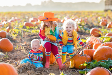 Kids picking pumpkins on Halloween pumpkin patch