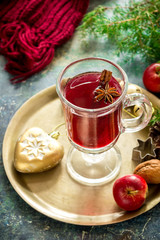 Mulled wine with apples, nuts and spices on copper tray. .