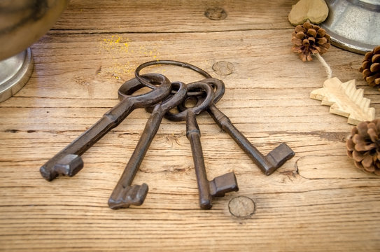 Rusty antique keys on wooden table as background