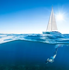 Crédence de cuisine en verre imprimé Plonger Young woman snorkeling under the boat