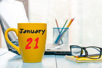 January 21st. Day 21 of month, Calendar on cup morning coffee or tea, teacher table background....