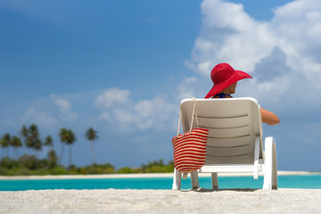 Young woman sunbathing on lounger at tropical beach