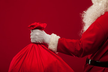 santa claus with big bag on shoulder glasses  red background