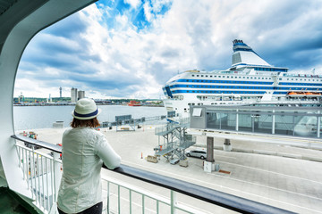 Woman relaxing and watching a cruiseship passing by