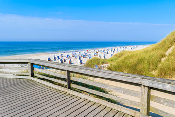 Coastal promenade along white sand beach with chairs in Kampen, Sylt island, Germany