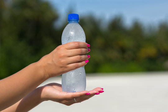 Woman hand holding water bottle outdoors