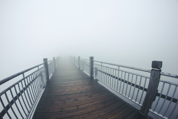 Mystic foggy wooden bridge background.
