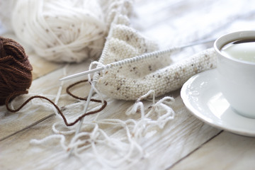 Skeins of wool and knitting needles on wooden background