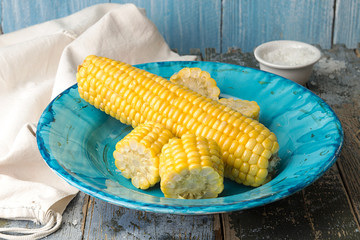 Boiled corn on deep blue plate