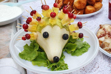 Food. On the table a plate of hedgehog zucchini, honey, candied fruit, grape, black chokeberry, cranberry. In the Belarusian traditions. Cranberry festival 