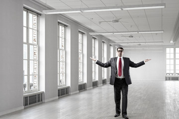 Businessman in empty office . Mixed media