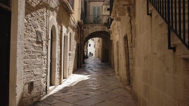 A narrow street in an old Italian town. Zooming in. Archival context establishing shot.
