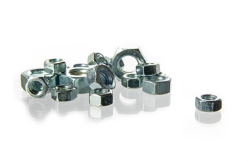 nuts of steel for machine bolts on a heap isolated on a white background