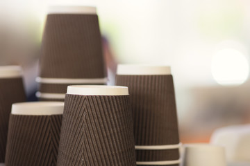 Piles of brown coffee cups over blurred background