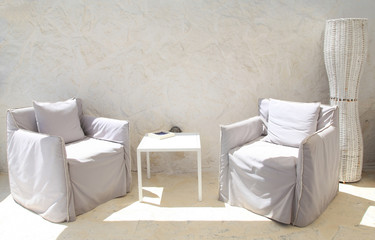Terrace lounge with white armchairs and wall